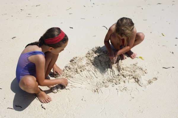Zanzibar, Paje, Two young girls playing in the hot sunshine of the sandy beach. 
Photo Nic I Anson