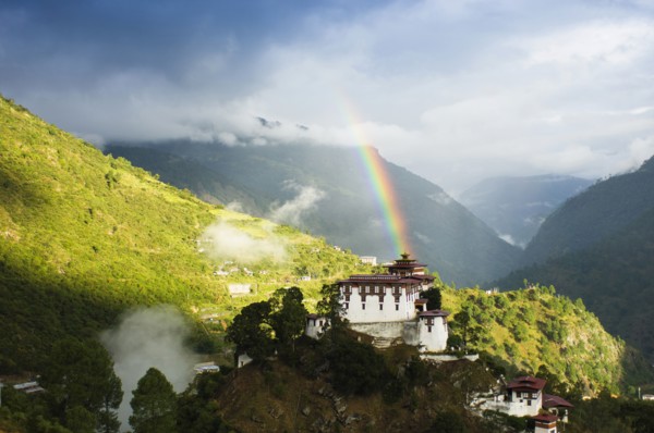 Bhutan, Lhuentse Dzong, Lhuentse Dzong with colourful rainbow overhead. 
Photo Nic I'Anson