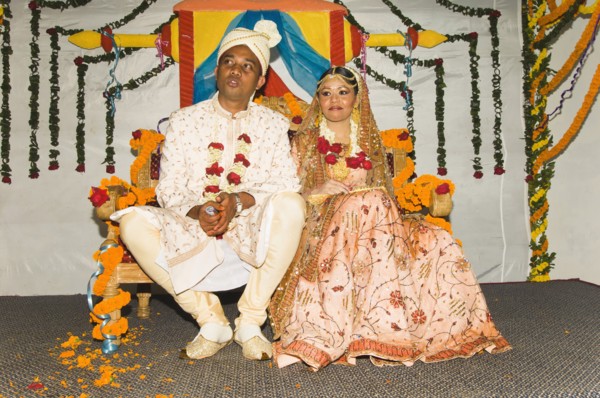 Bangladesh, Dahka, Bride and groom dressed up in glitzy jewellery and flowers for their wedding.