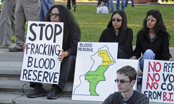 Canada, Alberta, Lethbridge, Three Blood Tribe members holding protest signs at anti-fracking