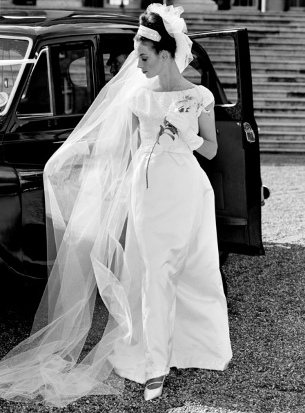 Model in a wedding dress posing next to a car, photo John French. UK, 1961. 
Londres, Victoria &
