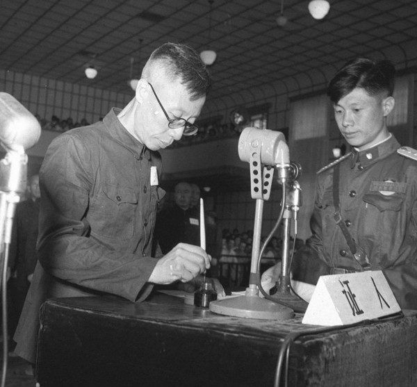 Pu Yi signant sa déclaration lors du procès de 28 criminels de guerre japonais, en juillet 1956