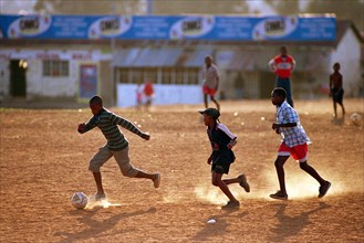 Soweto, South Africa                     April 19, 2001

Young boys kick up dust during an after