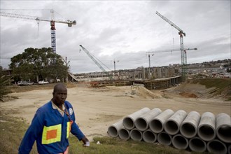 A worker knocks off work at the end of the day on the construction site of the Nelson Mandela Bay