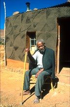 Blind Basotho man outside his home