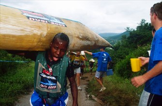 young black man covered in water walks just past the camera, guy