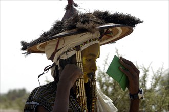 Wodaabe men examine their appearance in handmirrors at a festival in InGall, near Agadez in Niger