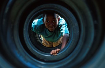 boy playing in a tyre