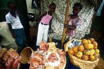 Mame Biramesy (centre) and Hade Faye (right) with a friend sell ground nuts and an indigenous fruit called magde