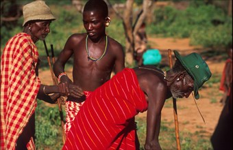 Kirana Lerimara, a young Samburu man takes the hand of one of his tribal elders