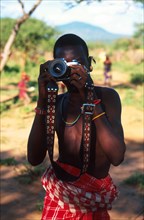 Tribesman comes up against modern technology: Kirana Lerimara, a young Samburu teenager looks through the wide-angle lens of my old Canon AE1 Program