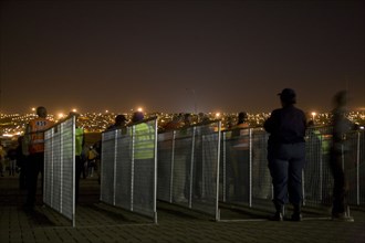 Jogi, A policewoman watches proceedings at an entry gate to Orlando Stadium