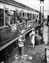Local residents supplying refreshments to trainload of British soldiers