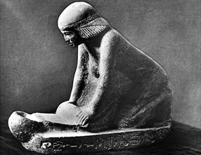 Egyptian woman grinding corn using a saddle quern