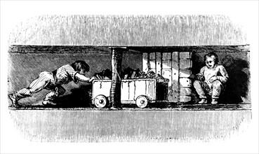 Boy pushing a truck loaded with coal