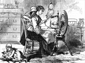 Female homeworker using a treadle spinning wheel