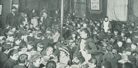 School children in the East End of London being served with free meals, c1910