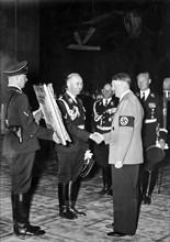 Heinrich Himmler offers Adolf Hitler a confiscated painting