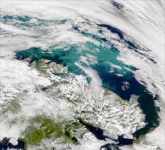 The clouds opened up enough on July 24, 2001, over the Barents Sea to reveal part of a suspected coccolithophore bloom to SeaWiFS