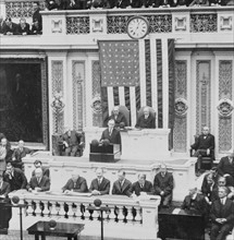 President Calvin Coolidge addressing the US Congress, Warren Harding is seated to the right of the Speaker