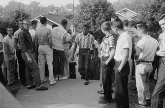 Line of African American boys walking through a crowd of white boys
