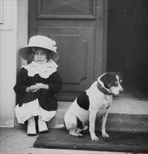 French girl sits in a doorway with a dog