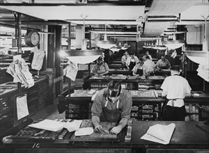 Typesetters and compositors put lead characters and letters into blocks for use in newspaper printing. American circa 1945