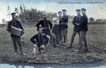 Russian border guards and one woman in dance poses. 1900