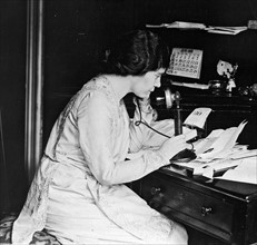 Suffragist Alice Paul using a telephone.