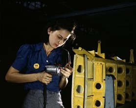 American female engineer during World War II, drilling horizontal stabilizers using operating a hand drill. ,