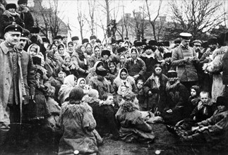 Crowd of refugees, (possibly Jewish), with three officials outdoors, Russia circa 1912
