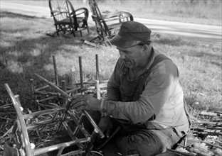 Migrant worker making cane chairs, near Paradis, Louisiana by Russell Lee, 1903-1986, dated 19380101.