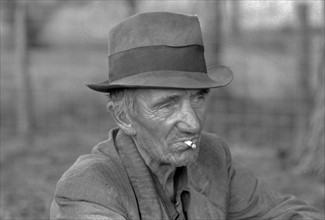 Migrant worker resting along roadside, Hancock County, Mississippi By Russell Lee, 1903-1986, photographer Date 19380101.