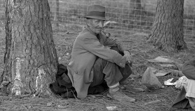 Migrant worker resting at roadside, Hancock County