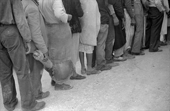 Vegetable workers, migrants, waiting after work to be paid. Near Homestead, Florida dated 19380101