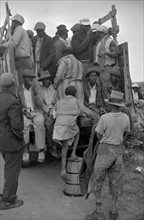 Vegetable workers, migrants, waiting after work to be paid. Near Homestead, Florida dated 19390101