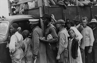 Vegetable workers, migrants, waiting after work to be paid. Near Homestead, Florida. dated 19380101