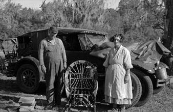 Migrant cane chair maker and wife in front of their automobile home, near Paradis, Louisiana 19380101