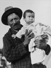 Migrant Mexican father holding his infant child, 1935