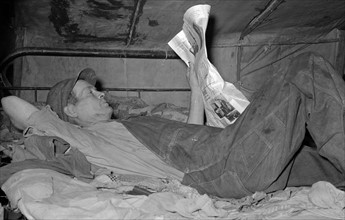 Migrant worker on bed in tent home. Mercedes, Texas. 19390101