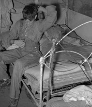 Son of white migrant worker putting on overalls in tent near Harlingen, 19390101