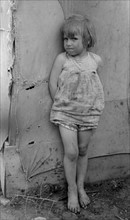 Child of white migrant worker standing by tent home near Harlingen, Texas by Russell Lee, 1903-1986, dated 19390101.