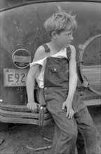 Child of white migrant worker sitting on bumper of their car from Arizona, near Harlingen, Texas by Russell Lee, 1903-1986, dated 19390101.