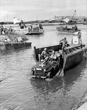 Photograph of a Jeep being rolled off a landing boat at Fedala harbour during the landing operations of the U.S. task forces