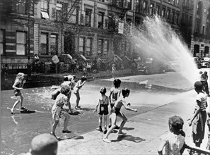 Children escape the heat of the East Side, New York, New York.