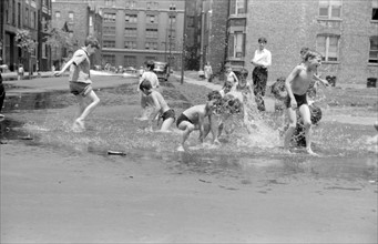 Untitled photo, possibly cooling off in water from hydrant. Photographer John Vachon.