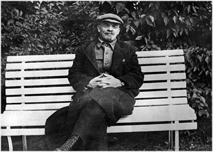 Vladimir Lenin seated on a bench.