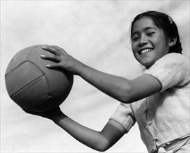 Photographic print of girl with volley ball at the Manzanar Relocation Centre, California