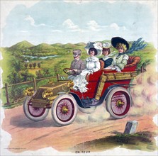 Three women and a man riding an automobile in the country, 1904.