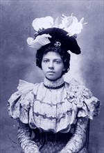 African American woman, head-and-shoulders portrait, facing front.